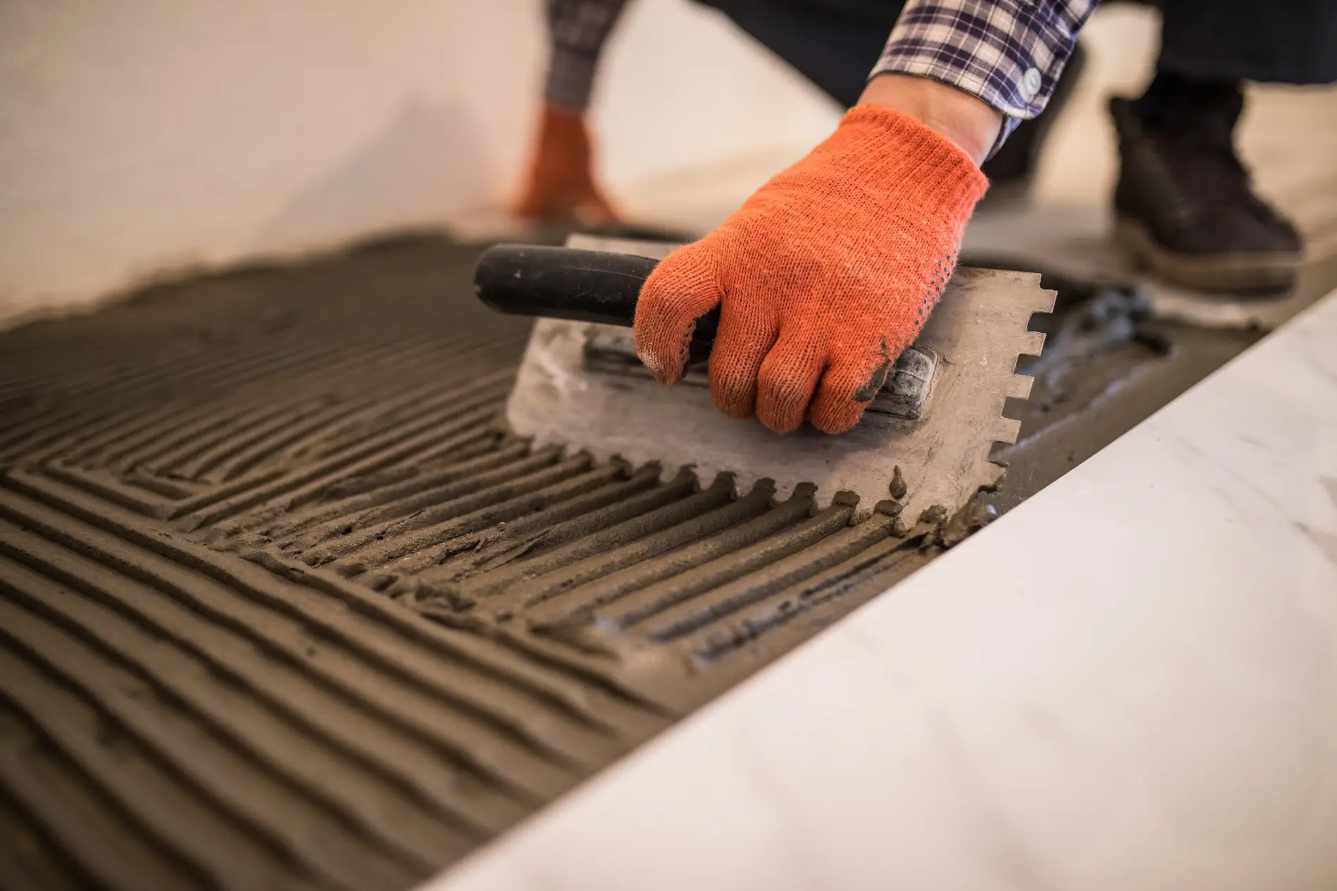 Artisan carreleur préparant le sol pour la pose de carrelage à Bruges
